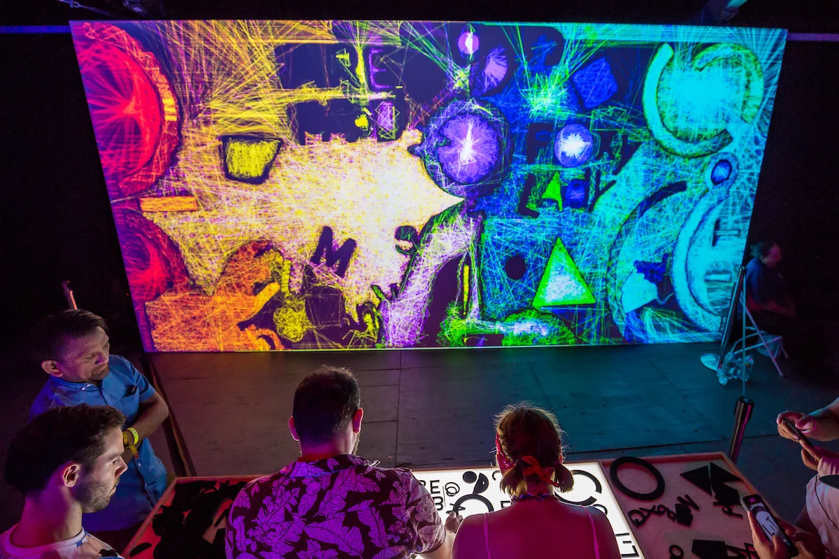 Visitors exploring a colorful projected wall