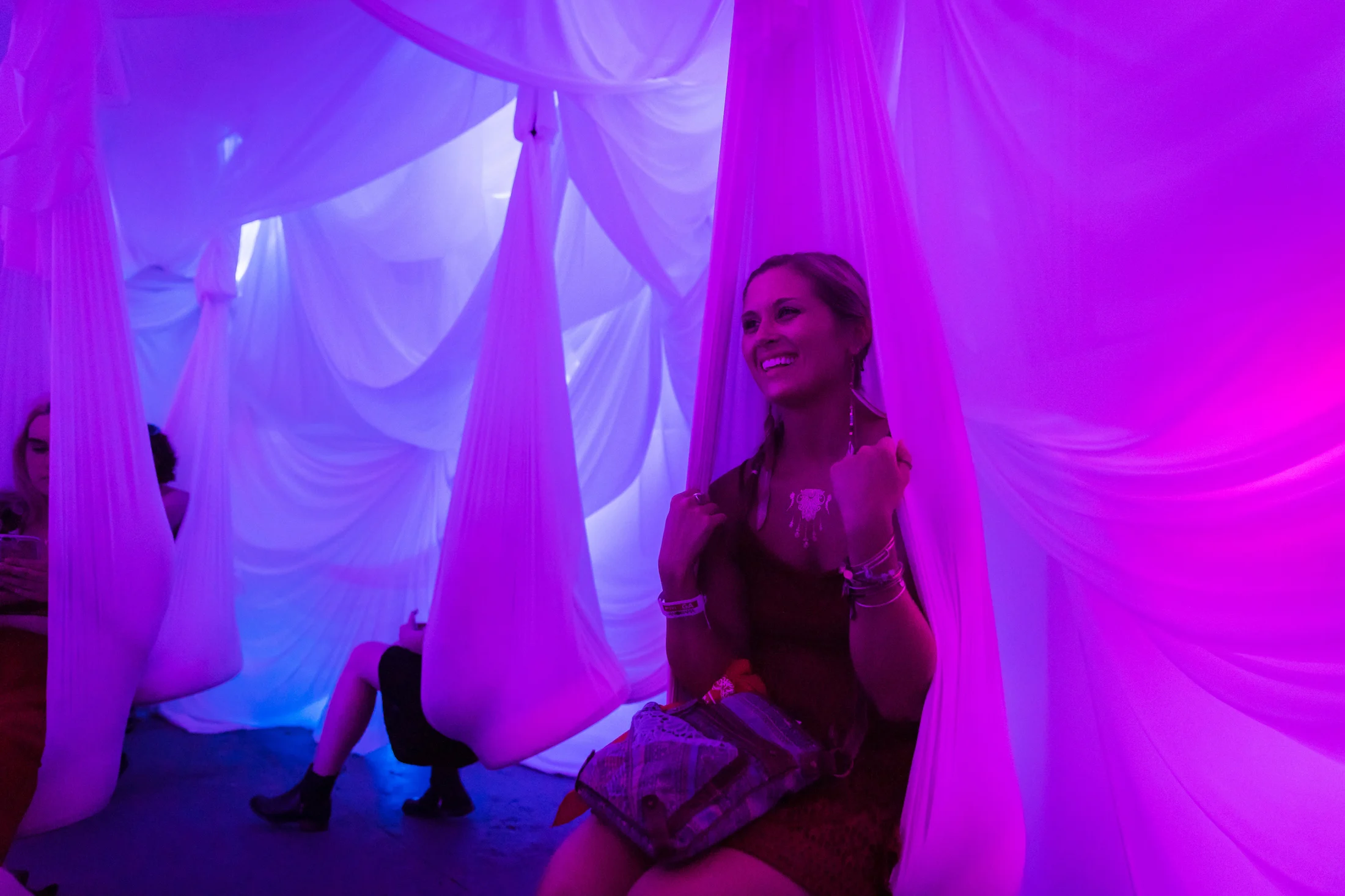 A visitor inside a violet-lit installation