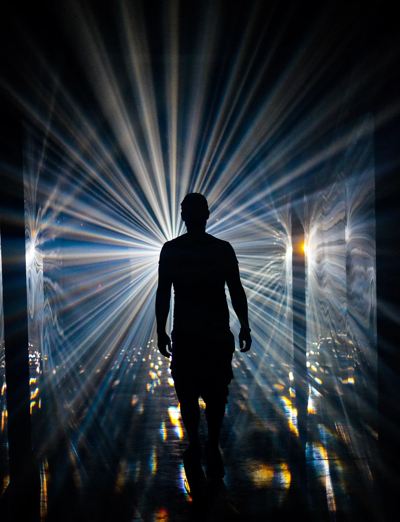 A silhouette surrounded by radiating white beams
