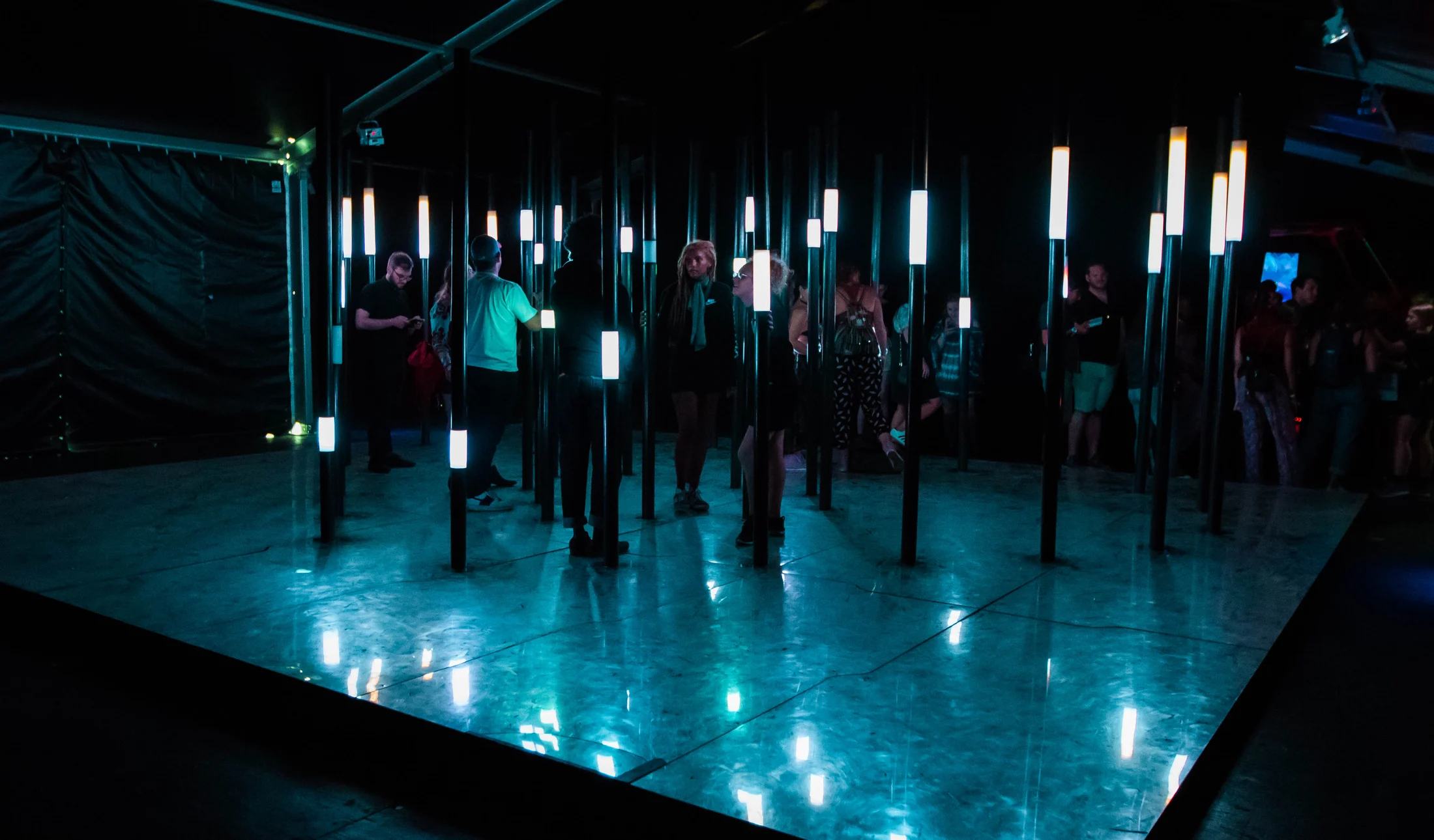 Visitors exploring a dark interactive installation
