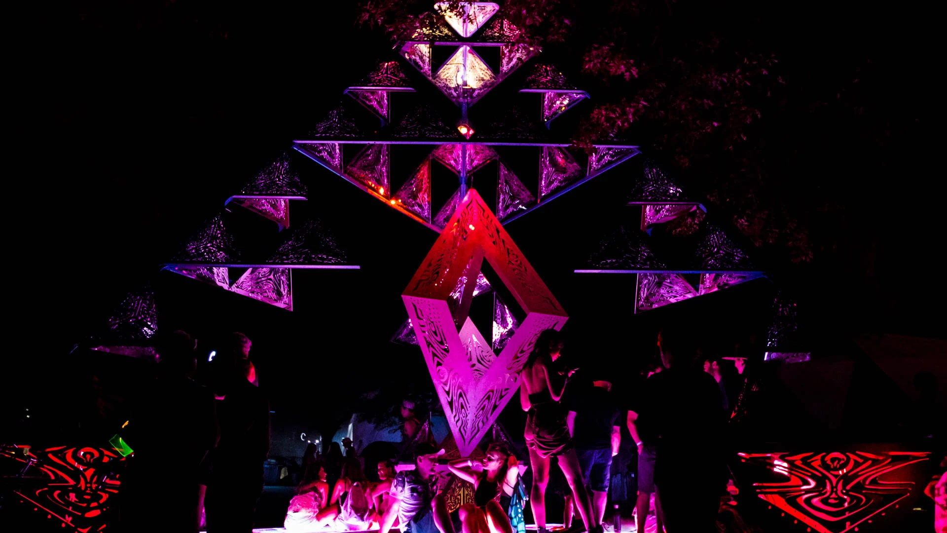 Visitors gathered beneath a luminous geometric sculpture