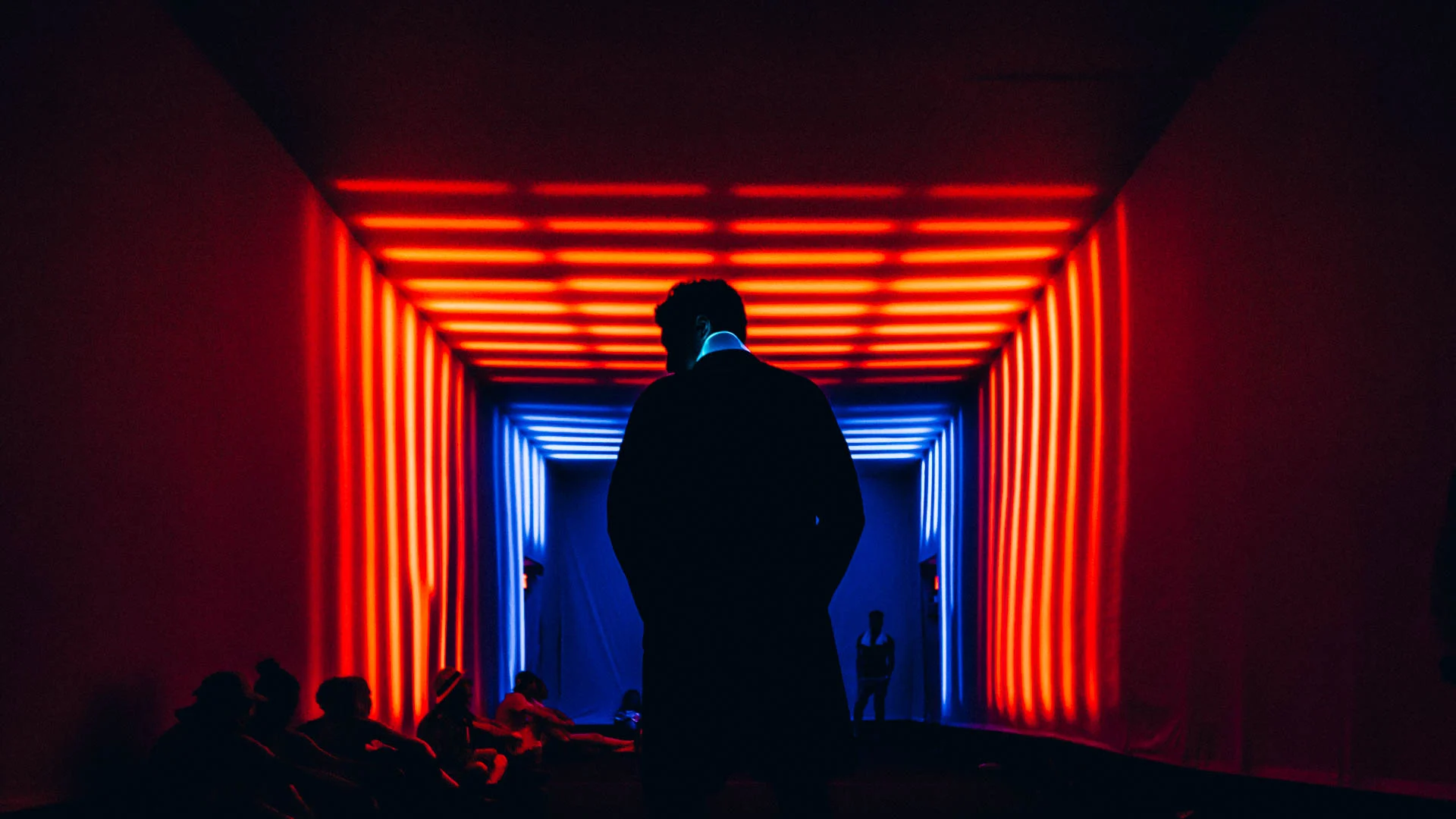 A visitor framed by a red illuminated passage