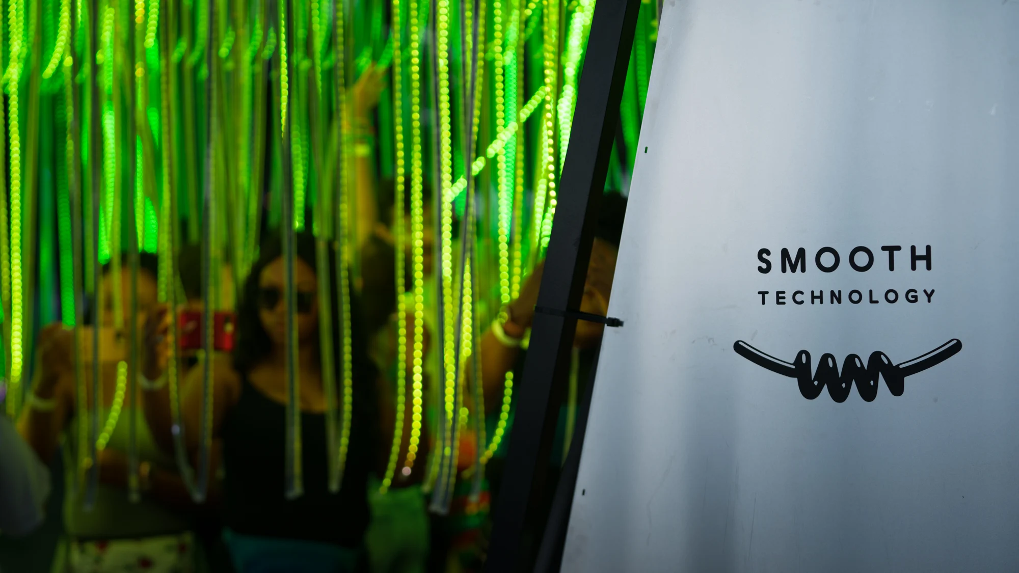 Visitors beneath suspended reflective strands