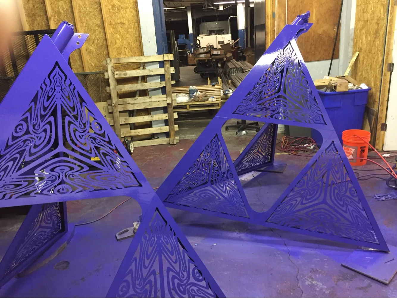 Purple triangular sculpture components during fabrication