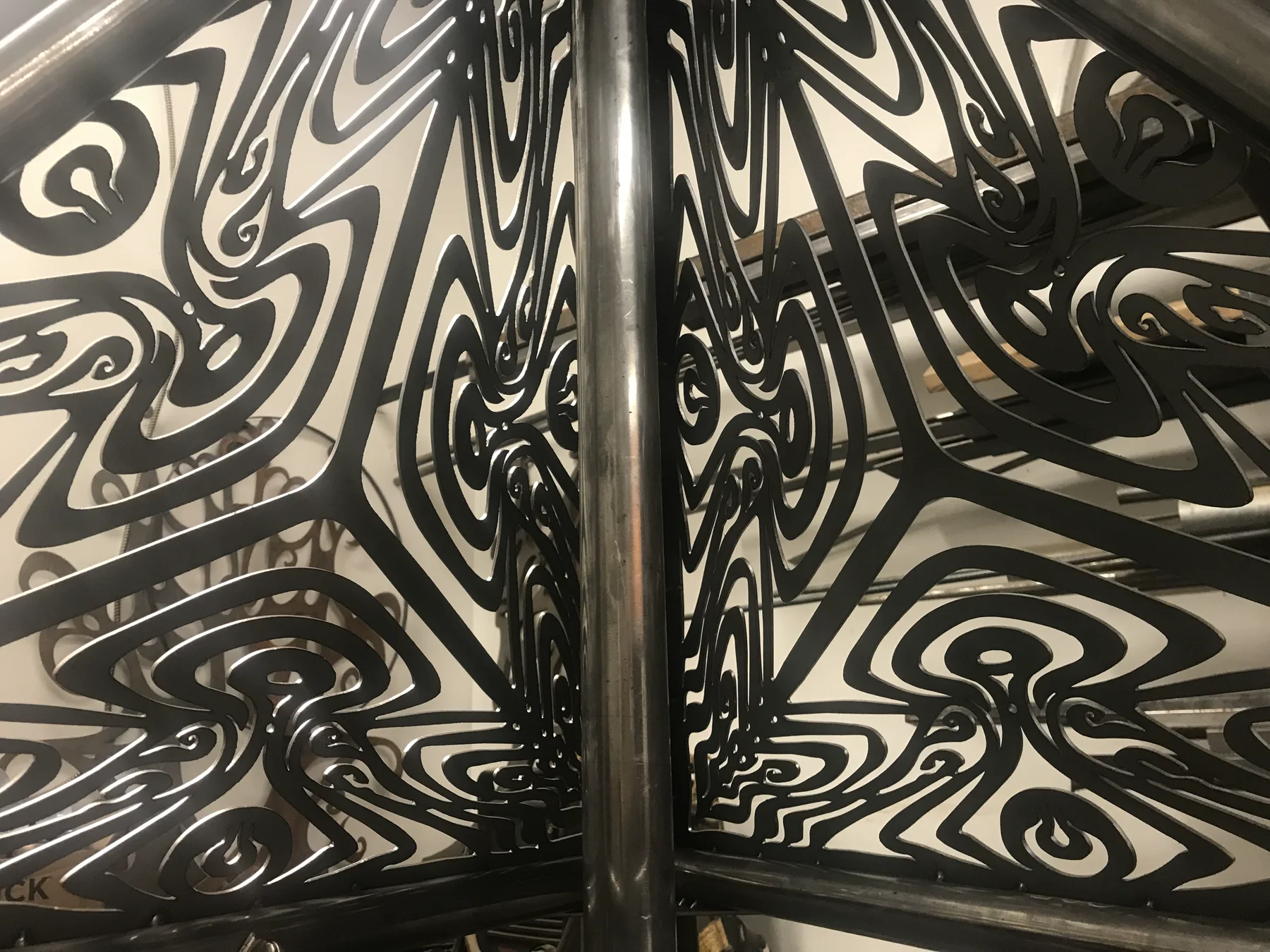 Patterned metal components casting shadows in the workshop
