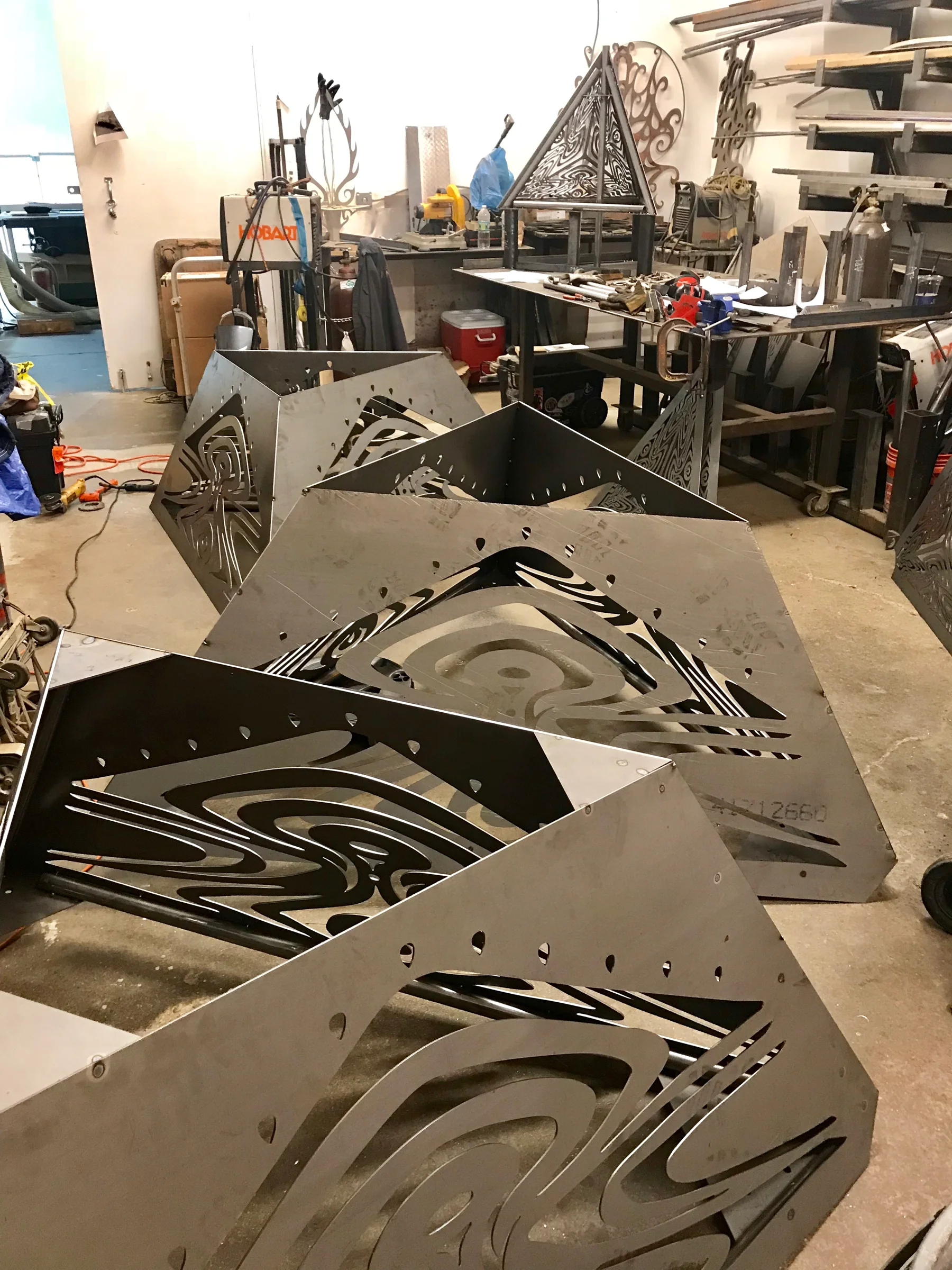 Sculpture components laid out on workshop tables